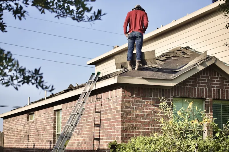 Professional roofer working on a residential roof in Rooney Valley